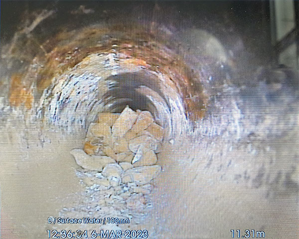 CCTV image showing pipe partially blocked by debris.