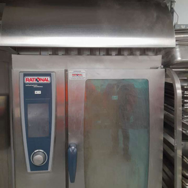 The self cleaning oven full of smoke with smoke billowing from the upper vents